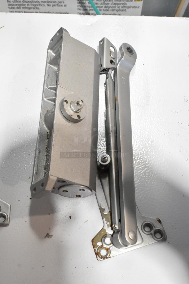 Ingersoll-Rand 4041 and Norton 1601 door closer, silver finish, used condition, visible mounting hardware.