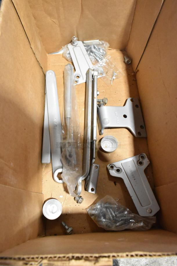 Box with Ingersoll-rand 4041 and Norton 1601 door closer parts, including assorted fasteners and brackets, in new condition.