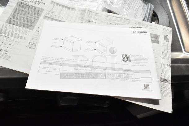 Samsung gas-powered range manual shown alongside documentation. Item is a brand new 4-burner, 2-oven range, missing grates.