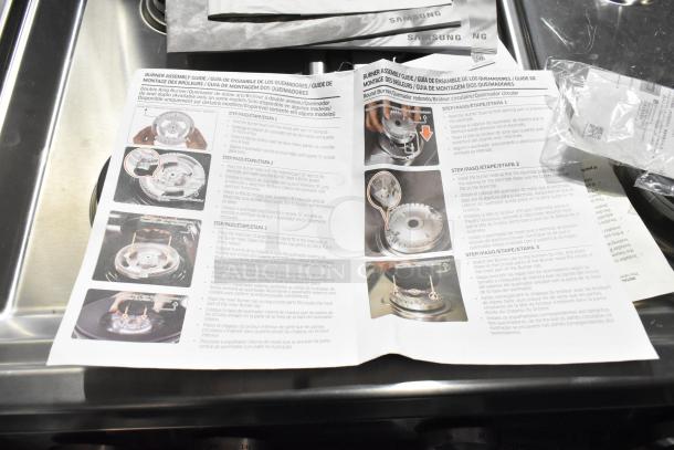 Brand new Samsung 4-burner gas range with 2 ovens. Scratch and dent, missing grates. Instruction manual visible.