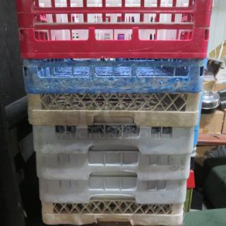 Assorted dishwasher racks, stacking set of four in red, blue, and beige. Used condition, ideal for organization. Model 7XBID.
