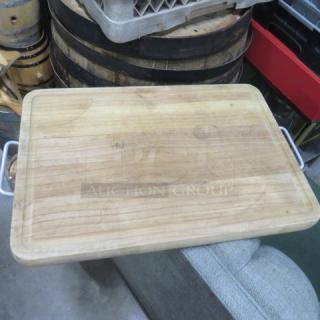12x17 wooden cutting board with metal handles, lightly used condition. Smooth surface with minor scratches.