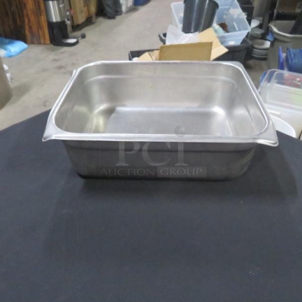 Half size 4 inch deep hotel pan, stainless steel, gently used, sturdy design, ideal for catering or restaurant use.