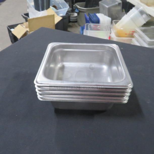 1/6 Size 2.5 Inch Deep Hotel Pan, stainless steel, stack of six, used, some signs of wear, suitable for commercial kitchens.