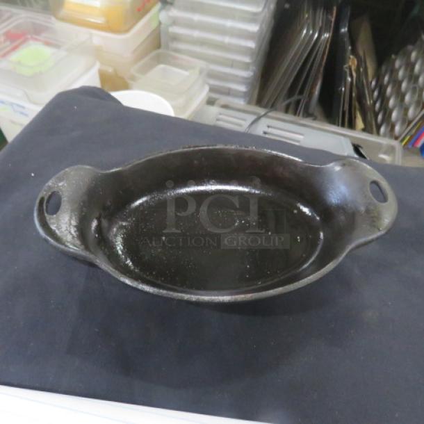Lodge Cast Iron Pre-Seasoned Oval Baking Dish with Handles, 9.5x5.5 inches, in good condition. Model 12XBID.