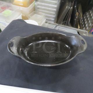 Lodge Cast Iron Pre-Seasoned Oval Baking Dish with Handles, 9.5x5.5 inches, in good condition. Model 12XBID.