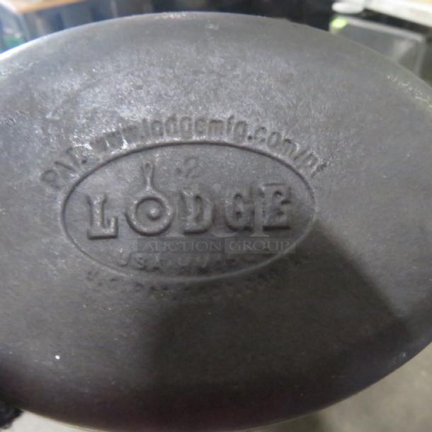 Lodge cast iron pre-seasoned oval baking dish with handles, 9.5x5.5 inches. Logo and website embossed on base.