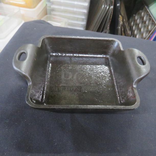 Lodge pre-seasoned square cast iron baking dish with handles, 5x5 inches, shown in good condition.