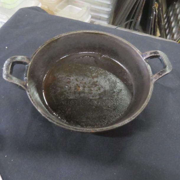 Valor 6.5" round cast iron baking dish with handles, pre-seasoned, shows signs of use, model 12XBID.