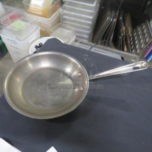 Williams Sonoma All Clad stainless steel 8.5-inch sauté pan in used condition, visible wear on cooking surface, sturdy handle.