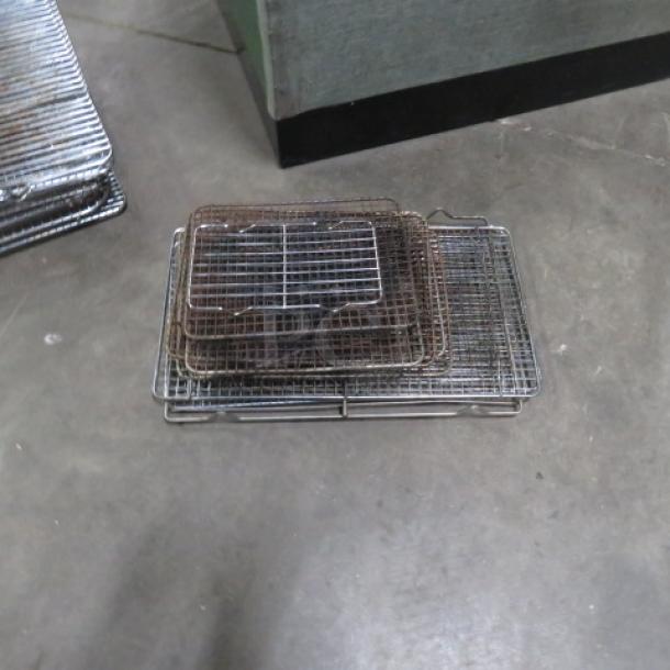 Assorted size cooling racks in stacked arrangement, used condition, metal construction, ideal for baking and cooling.