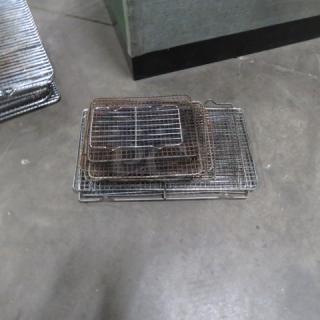 Assorted size cooling racks in stacked arrangement, used condition, metal construction, ideal for baking and cooling.