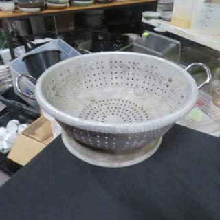 15.5-inch aluminum colander with handles, perforated design. Used condition, suitable for straining and draining.