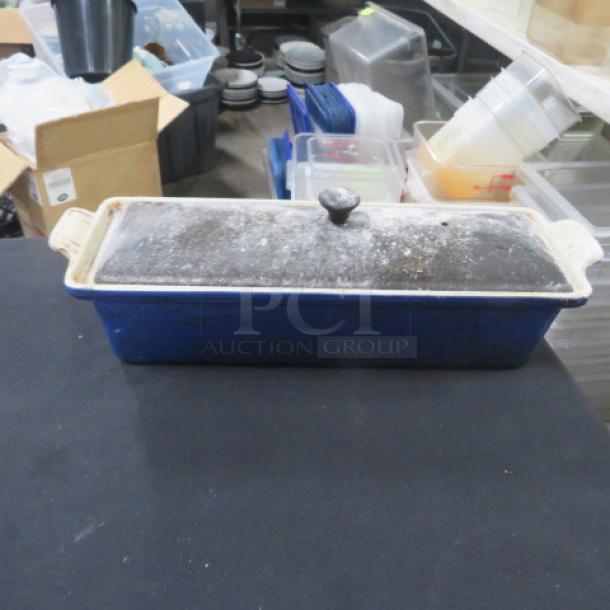 La Creuset 2 Qt terrine baker with lid, blue, signs of wear, ideal for pâté or terrines, known for even heat distribution.