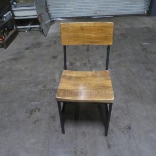 Industrial black metal chair with wooden seat and back, sturdy design, slightly worn condition. Model: 4XBID.