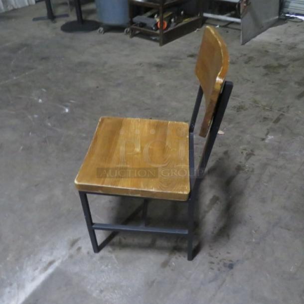 Industrial black metal chair with wooden seat and back. Good condition, sturdy frame. Model: 4XBID.