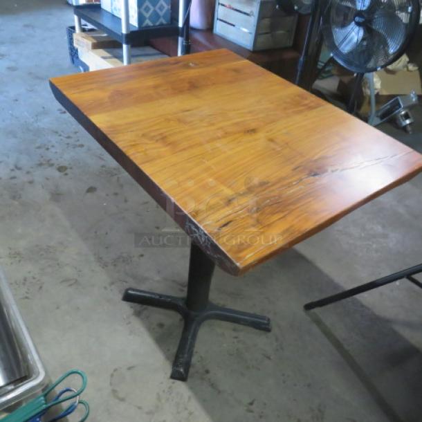 Solid wooden table with a polished top and a black pedestal base, measuring 24x30x30 inches. Minimal wear.
