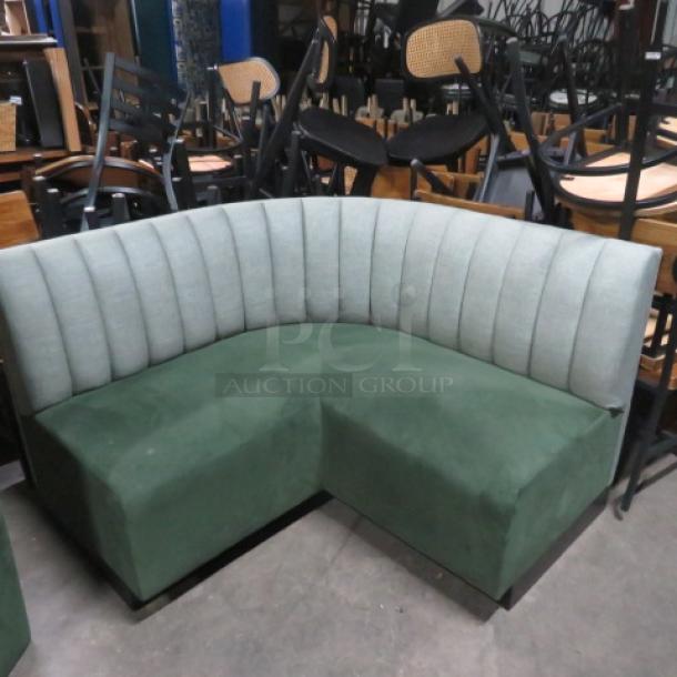 Green cushioned corner booth/bench, single-sided, 53x53x34 inches. Good condition, vertical pattern on backrest.