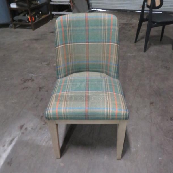 Green cushioned Pottery Barn dining chair with plaid pattern, wooden legs, and a gently used condition.