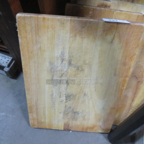 24x18x2 solid wood cutting board with visible wear. Natural grain pattern. Slightly worn surface. Auction tag attached.