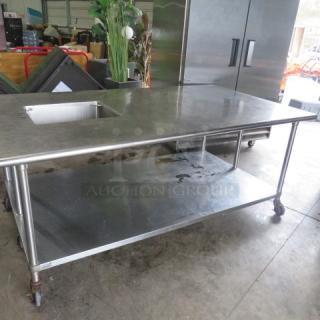 One stainless steel table with sink and under shelf, measures 84x48x35, on casters, in used condition.