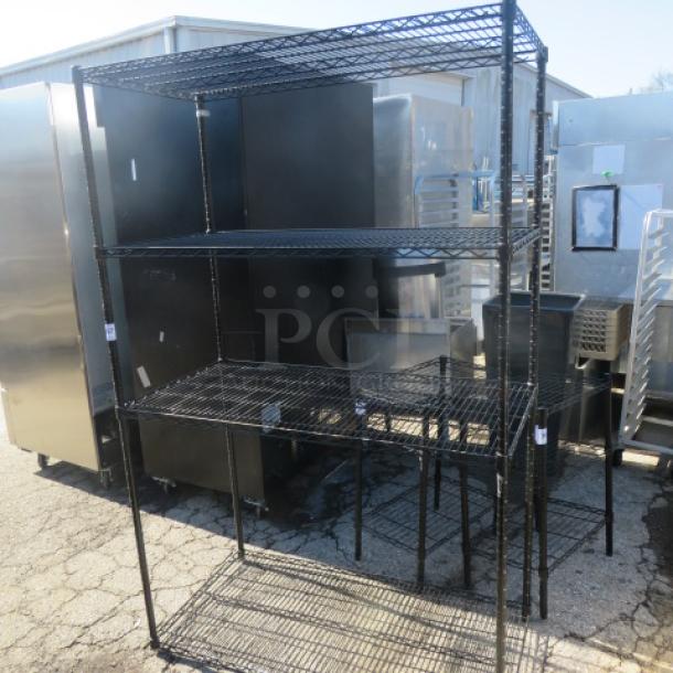 Black Metro shelf unit with 4 wire shelves, 48x24x75 inches, sturdy metal construction, suitable for storage.