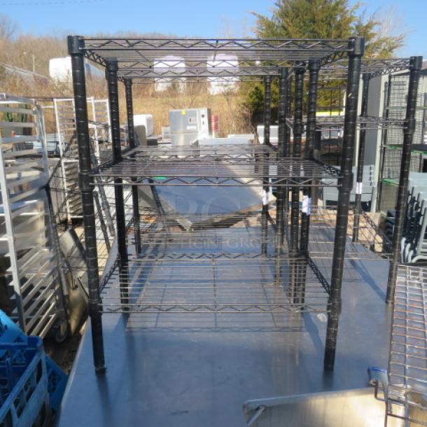 One black Metro shelf unit with four adjustable wire shelves, 24x14x31 inches, outdoors in good condition.