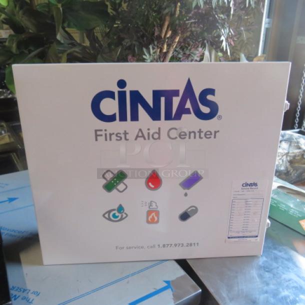 Cintas First Aid Center with logo and symbols, wall-mountable, in good condition. Includes contact info for service.