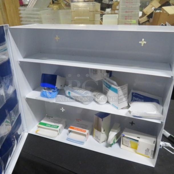 Cintas First Aid Center with open shelves displaying various medical supplies. White metal cabinet in good condition.