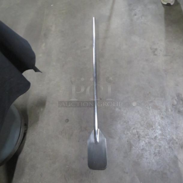 Stainless steel paddle with flat blade, in excellent condition, ideal for mixing or stirring.