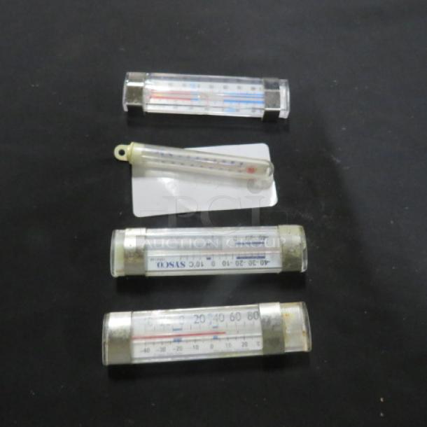 Assorted thermometers, four total, varying sizes, clear casings with Celsius and Fahrenheit scales, condition moderate.