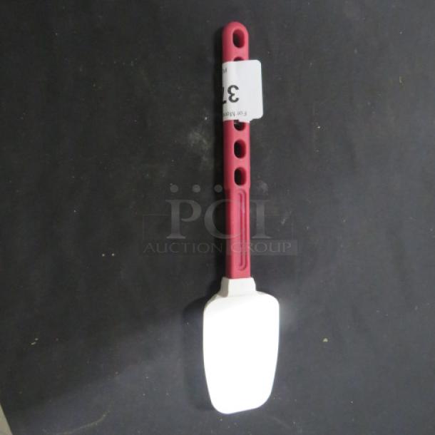 Red-handled spatula with white silicone head, perforated grip, and attached tag. Good condition, ideal for cooking tasks.