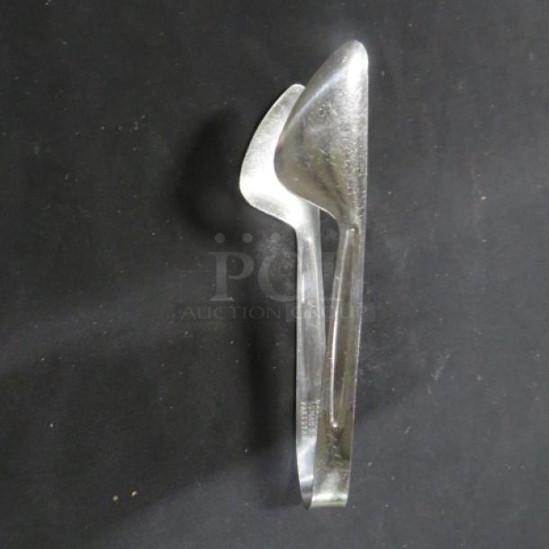 Stainless steel tong, polished finish, moderate wear, featuring a robust grip design. Marked "5XBID."
