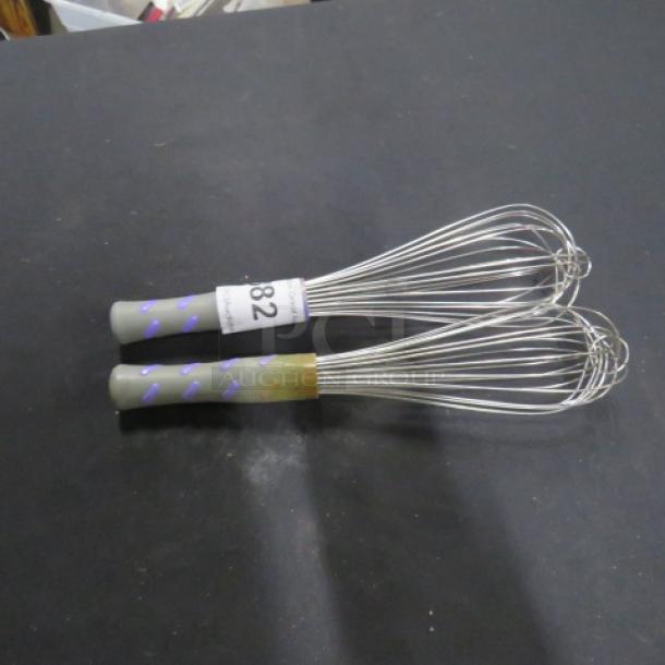 Commercial whisks with gray and purple handles, stainless steel wires. Visible tag reads "82". Good condition.