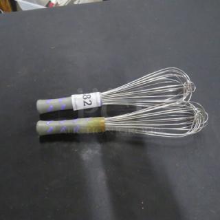 Commercial whisks with gray and purple handles, stainless steel wires. Visible tag reads "82". Good condition.