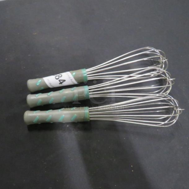 Three commercial whisks with metal wires and green handles, labeled "84." In good condition, suitable for professional kitchens.