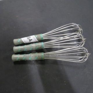 Three commercial whisks with metal wires and green handles, labeled "84." In good condition, suitable for professional kitchens.