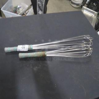 Two commercial whisks with stainless steel wires and green-handled grips. Good condition. Mark labeled "35."