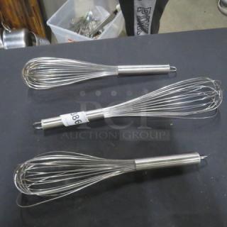 Three stainless steel commercial whisks with loop handles; one marked with tag "986." In good condition.