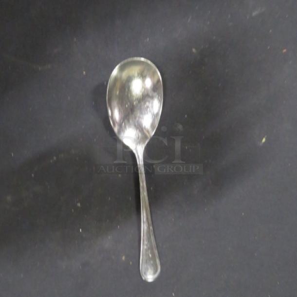 One stainless steel serving spoon, part of a lot of 25, reflective finish, in good condition.