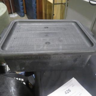 Black bussing tube with lid, model 3XBID. Features sturdy plastic construction. Good condition, minor wear visible.