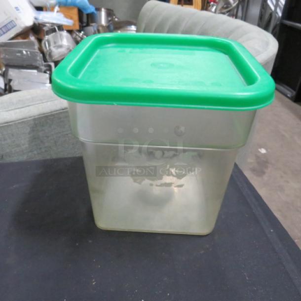 4-quart food storage container with green lid, labeled 4XBID. Lightly used with some residue on the side.