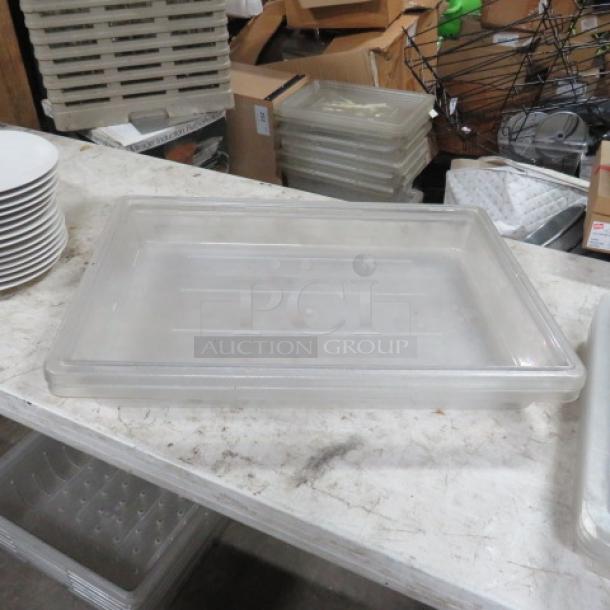 Clear rectangular food storage container, approximately 5-gallon capacity, used condition, stackable design, no visible labels.