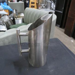 Stainless steel Acopa water pitcher, model 5XBID, with modern cylindrical design and sleek handle, in good condition.