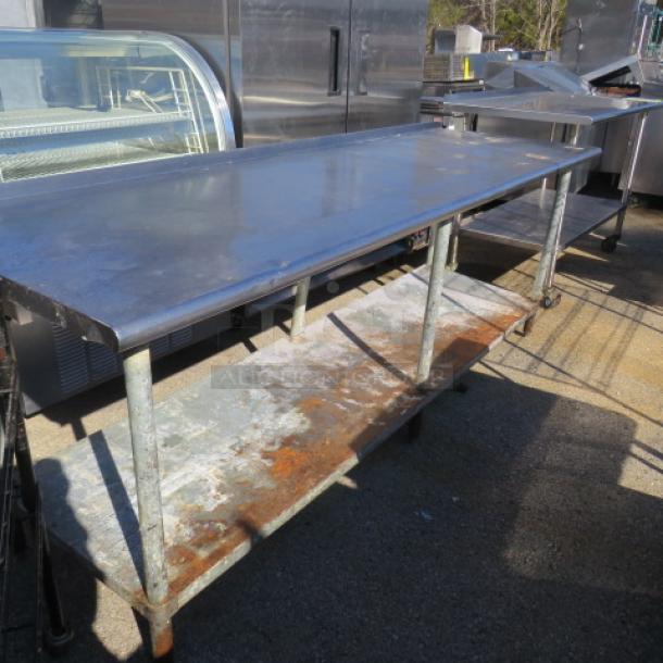 Stainless steel table with under shelf, 96x30.5x36 inches. Used condition, visible surface wear. Ideal for kitchen use.