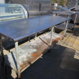 Stainless steel table with under shelf, 96x30.5x36 inches. Used condition, visible surface wear. Ideal for kitchen use.