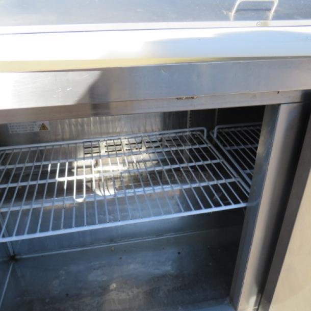 Avantco 2-door refrigerated prep table interior, featuring 2 racks, stainless steel shelves, and ticket rails. Model 178SSPT60HC.