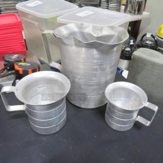 Assorted aluminum measurer set with three pieces, varying sizes, sturdy handles, and visible measurement markings. Used condition.