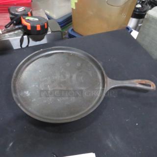 LODGE 10.5-inch cast iron sizzler pan, round shape, long handle, used condition with some surface wear.