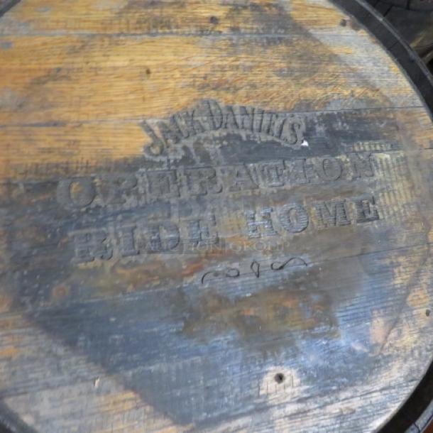 Jack Daniels whiskey barrel, wood with visible branding "Operation Ride Home," used condition, circular shape.